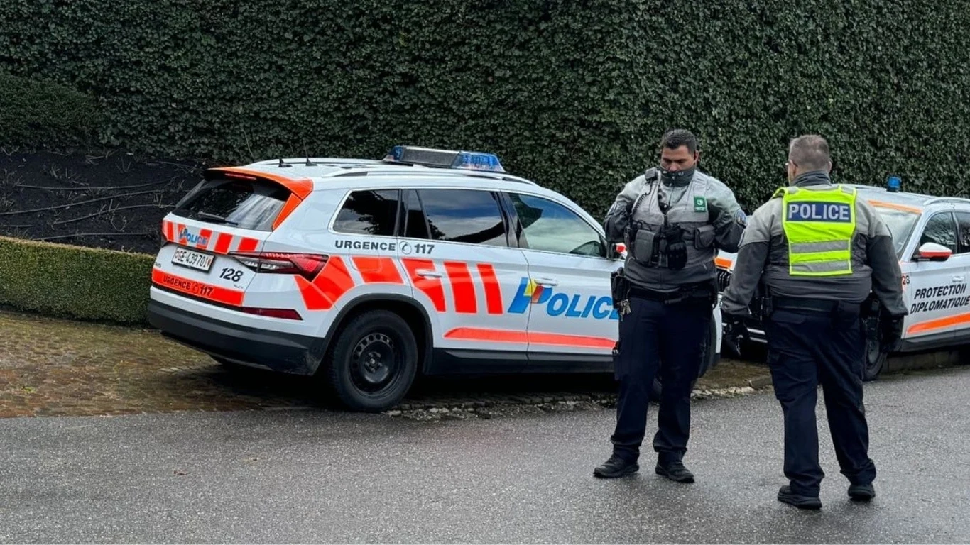 Szwajcarska policja (zdj. ilustracyjne) Szwajcarska policja przy zaparkowanych radiowozach z oznaczeniami, na tle zielonego żywopłotu
