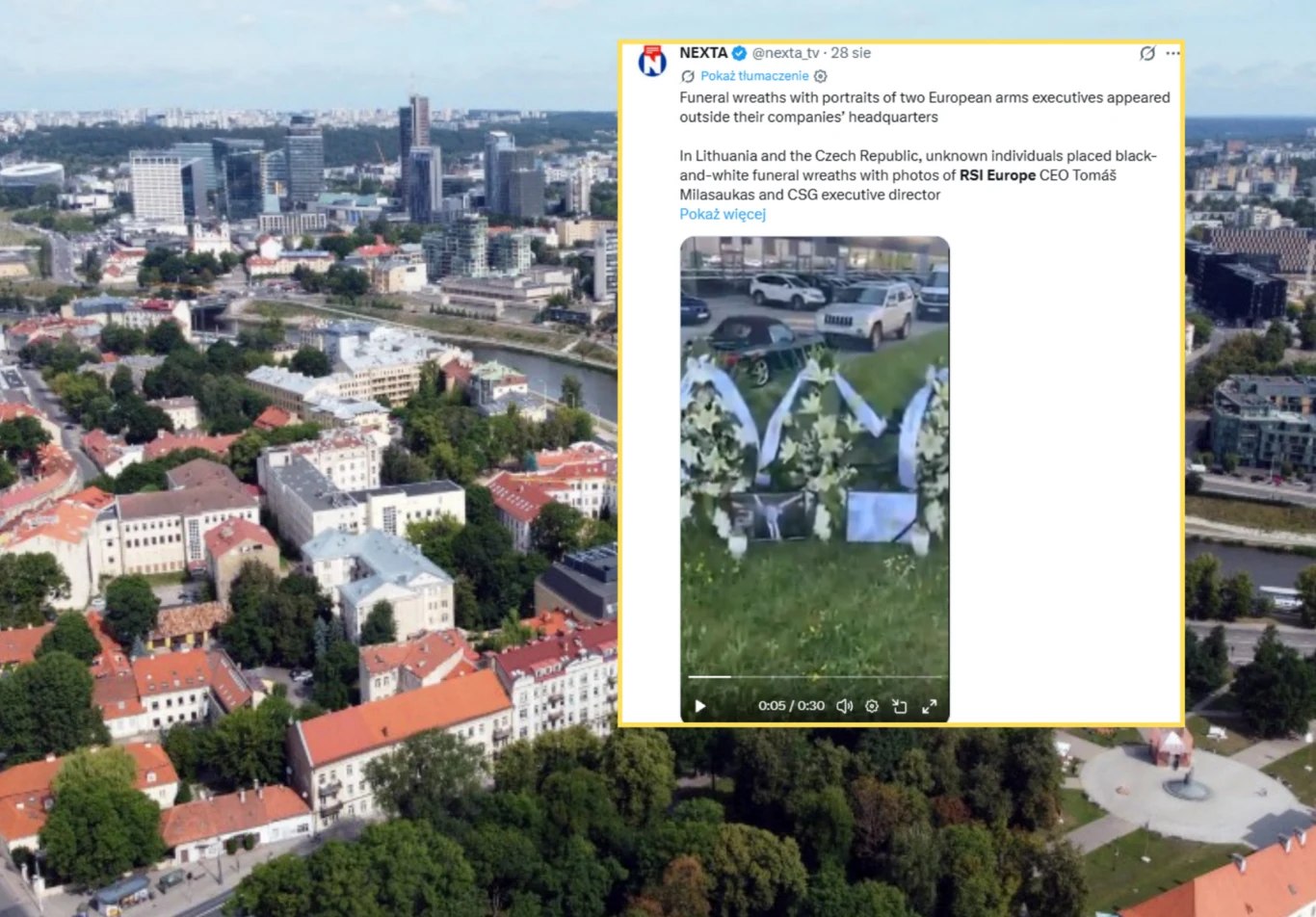 Wieńce pogrzebowe postawiono przed siedzibą firmy zbrojeniowej w stolicy Litwy. Na zdj. w tle panorama Wilna Wieńce pogrzebowe z czarno-białymi zdjęciami przed siedzibą firmy zbrojeniowej w Wilnie, panorama miasta w tle.