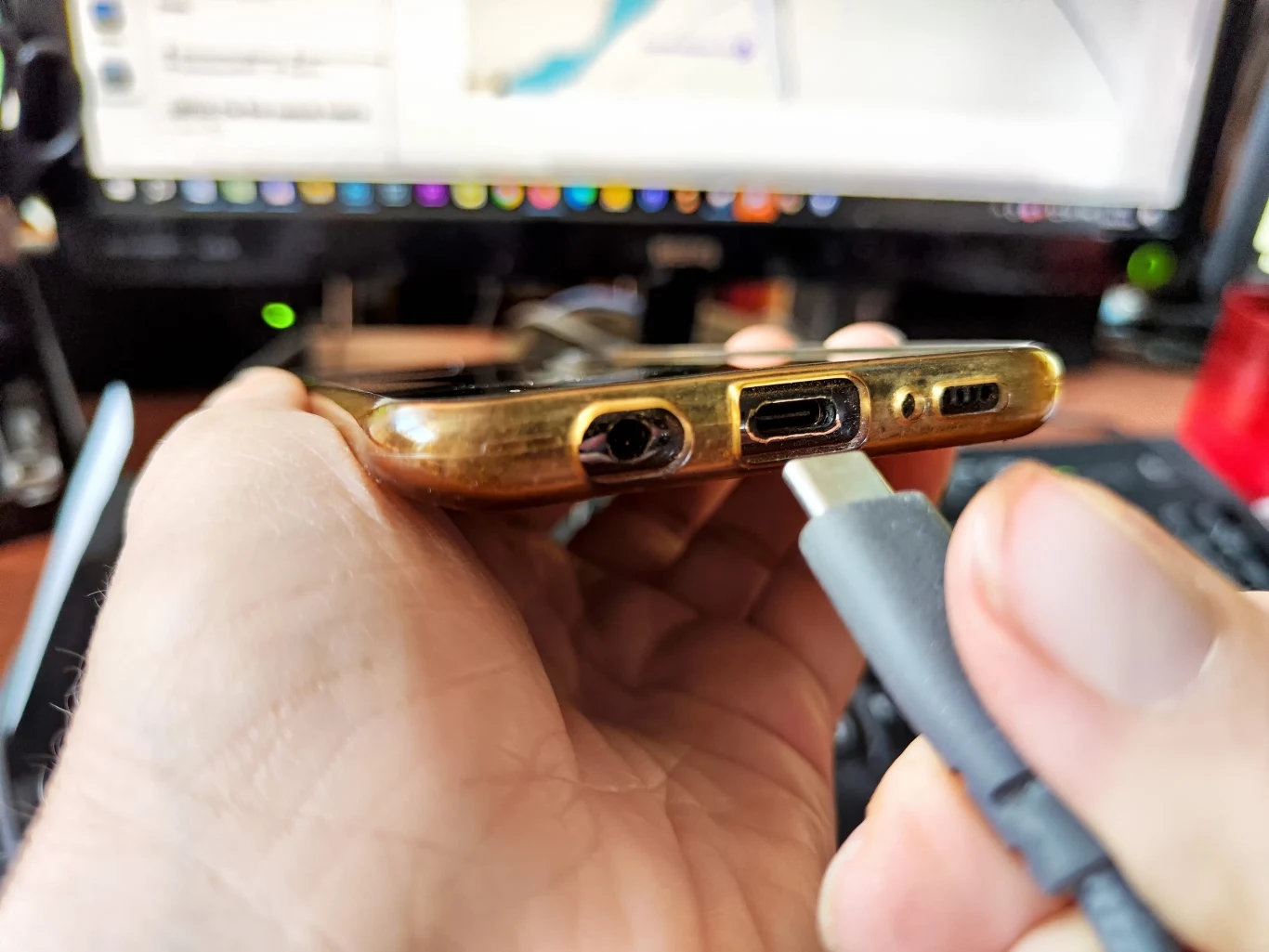Telefon nie chce się ładować? Przyczyną nie zawsze jest zepsuty kabel, czasem wystarczy wyczyścić port USB-C. Dłoń trzymająca smartfon z portem USB-C.