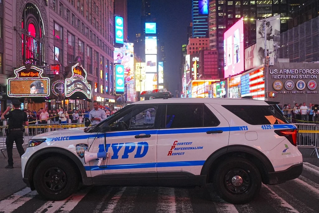 Nowy Jork. Atak nożowniczki na Times Square. Jedna osoba nie żyje Radiowóz policji Nowego Jorku na Times Square otoczony barierkami i przechodniami, w tle reklamy świetlne.