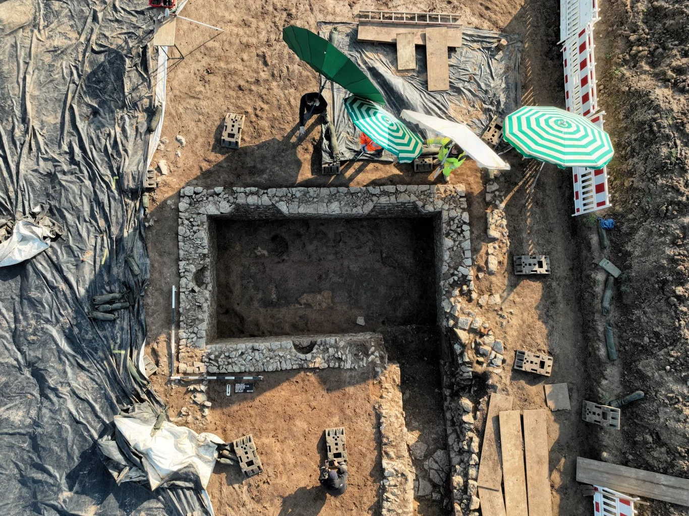 Niemieccy archeolodzy badają tajemnicę dawnej rzymskiej osady. Nagle opustoszała. Kamienna prostokątna struktura na terenie wykopalisk rzymskiej osady z archeologicznym wyposażeniem.