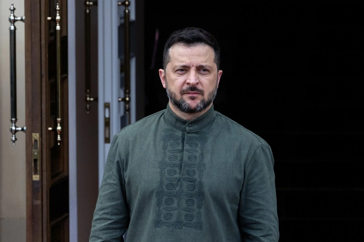 Prezydent Ukrainy Wołodymyr Zełenski ostrzega ws. rosyjskiej przestrzeni powietrznej Wołodymyr Zełenski w ciemnozielonej koszuli stoi przy otwartych drzwiach, patrząc przed siebie.