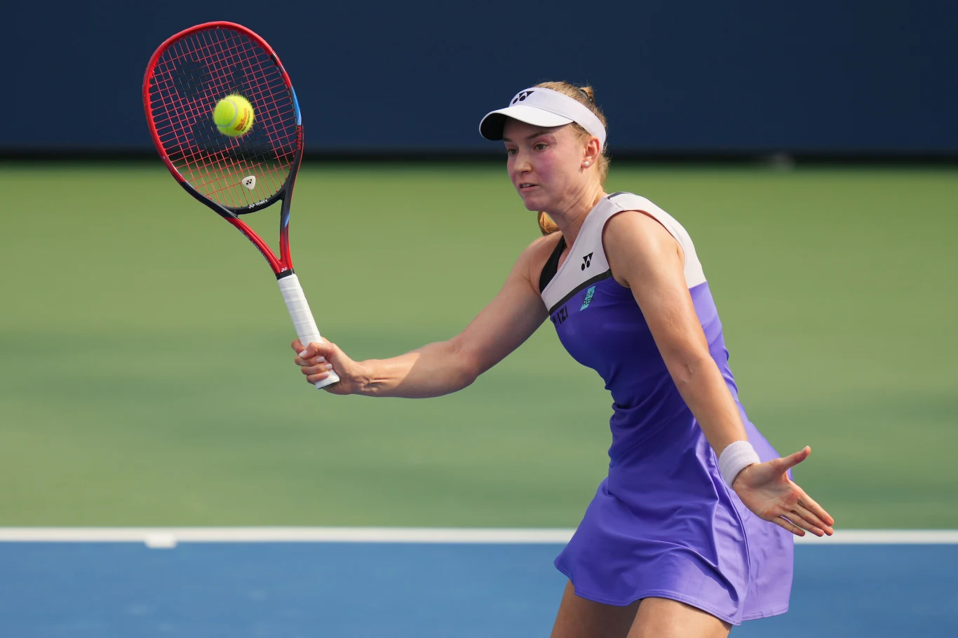 Jelena Rybakina, US Open 2026 Tenisistka w fioletowej sukience odbija piłkę rakietą podczas meczu na korcie tenisowym.