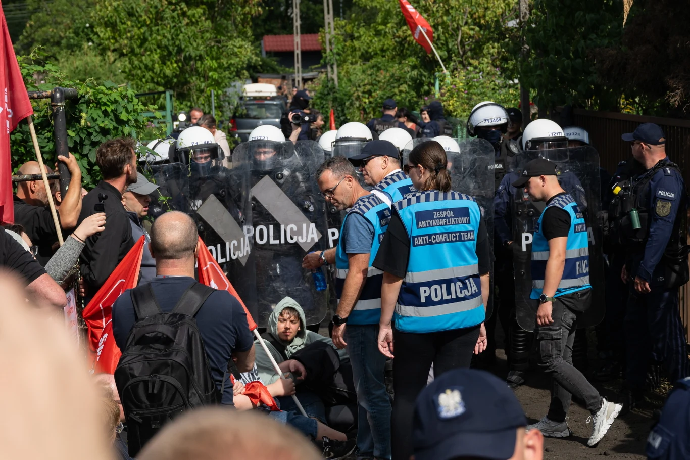 Policja podczas protestu przeciw eksmisji komorniczej na Osiedlu Maltańskim w Poznaniu Policjanci w kaskach i z tarczami oddzielają protestujących z flagami na Osiedlu Maltańskim w Poznaniu.