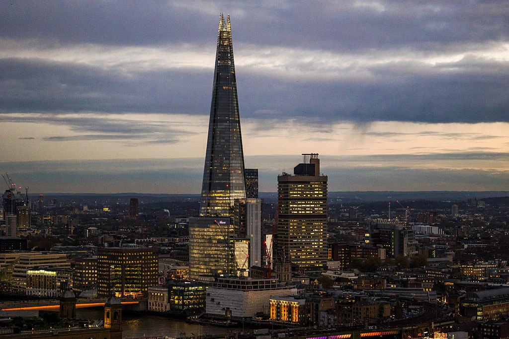 Widok na wieżowiec Shard w Londynie Wieżowiec The Shard dominuje nad panoramą miasta, otoczony niższą zabudową i sąsiednimi nowoczesnymi budynkami biurowymi, podkreślając kontrast między architekturą tradycyjną a współczesną.
