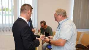 Prezydent Miasta Ełku Tomasz Andrukiewicz odbierający pamiątkę od działacza Solidarności