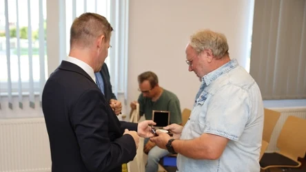 Prezydent Miasta Ełku Tomasz Andrukiewicz odbierający pamiątkę od działacza Solidarności