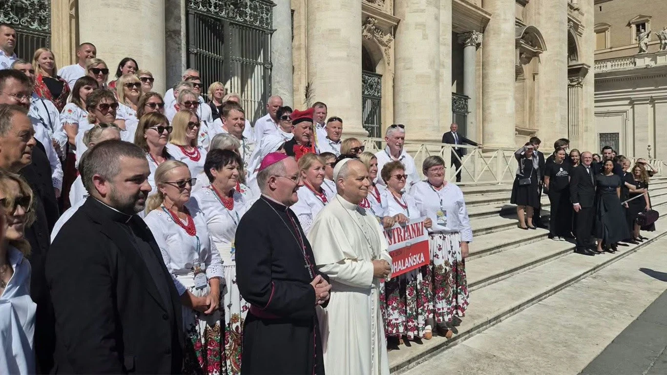 Górale przyjechali z Podhala. Wręczyli Leonowi XIV prezent Grupa osób w tradycyjnych strojach góralskich i duchowni przed budynkiem z kolumnami, z banerem Bystra Podhalańska.