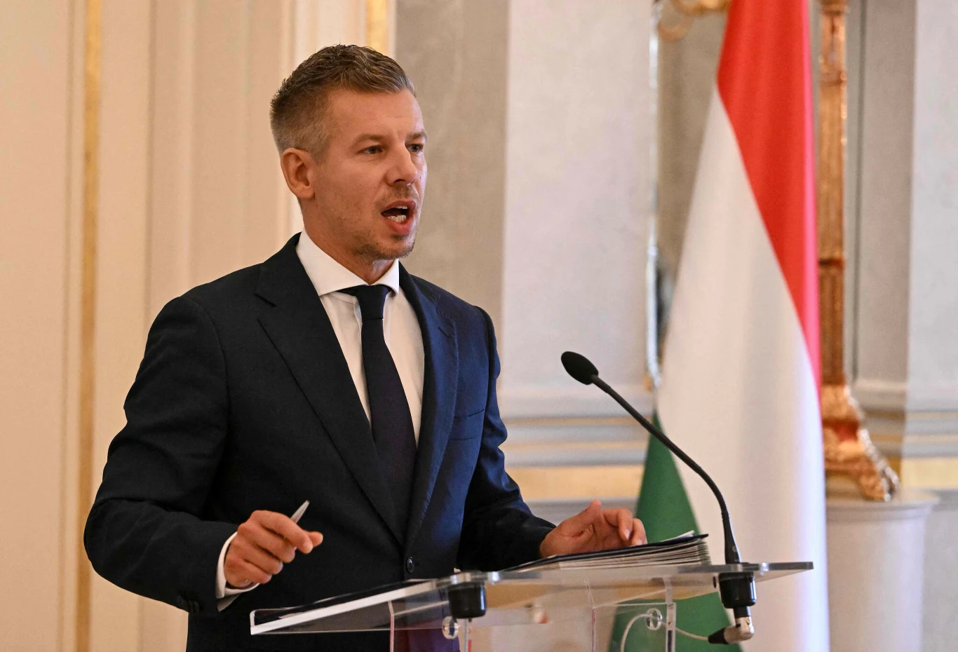 Peter Magyar po objęciu władzy na Węgrzech ma kolejny problem - to potężne upały niszczące kraj Peter Magyar przemawia przy mównicy, obok duża węgierska flaga biało-czerwono-zielona.