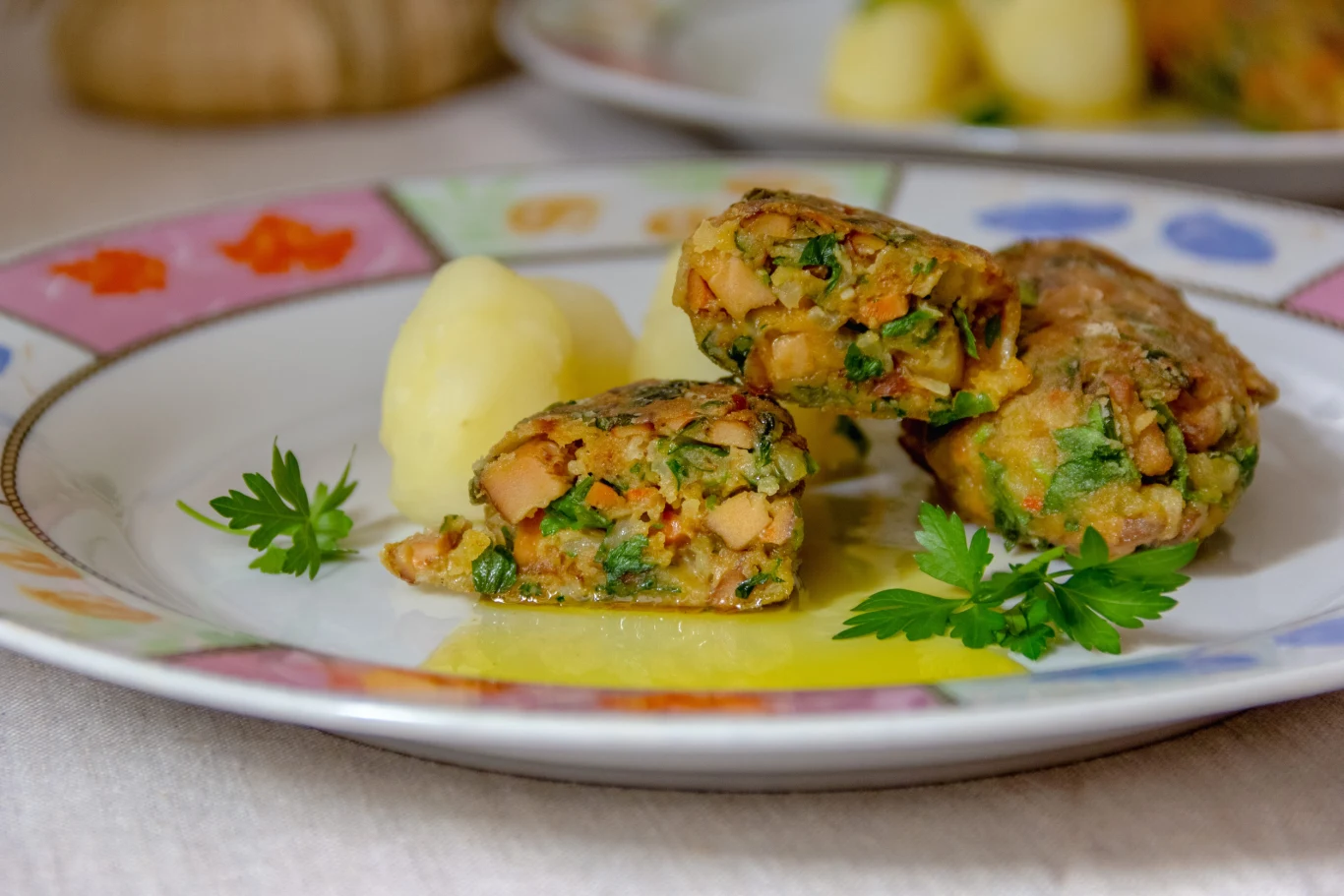 Soczyste i kolorowe kotlety warzywne z piekarnika. Twoja rodzina pokocha je bardziej niż mielone. Kotlety warzywne z kawałkami marchwi, pietruszki i ziół z puree ziemniaczanym i natką na talerzu.