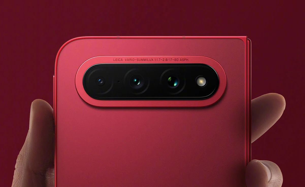 Składany Xiaomi 18 Fold zaprezentowany. Specyfikacja telefonu jest mocna. Czerwona obudowa Xiaomi 18 Fold z poziomym potrójnym aparatem, smartfon trzymany w dłoni.
