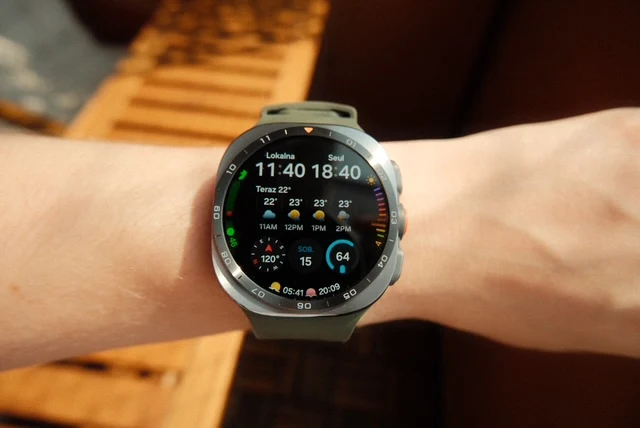 Smartwatch na ręce z wyświetlaczem pokazującym aktualną godzinę, datę oraz szczegółową prognozę pogody wraz z temperaturą, wilgotnością i trendami pogodowymi.