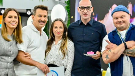 Pięć uśmiechniętych osób w kolorowych ubraniach pozuje razem w pomieszczeniu; jedna trzyma podkładkę z logo '"halo tu polsat", inna kawałek ciasta na talerzyku.