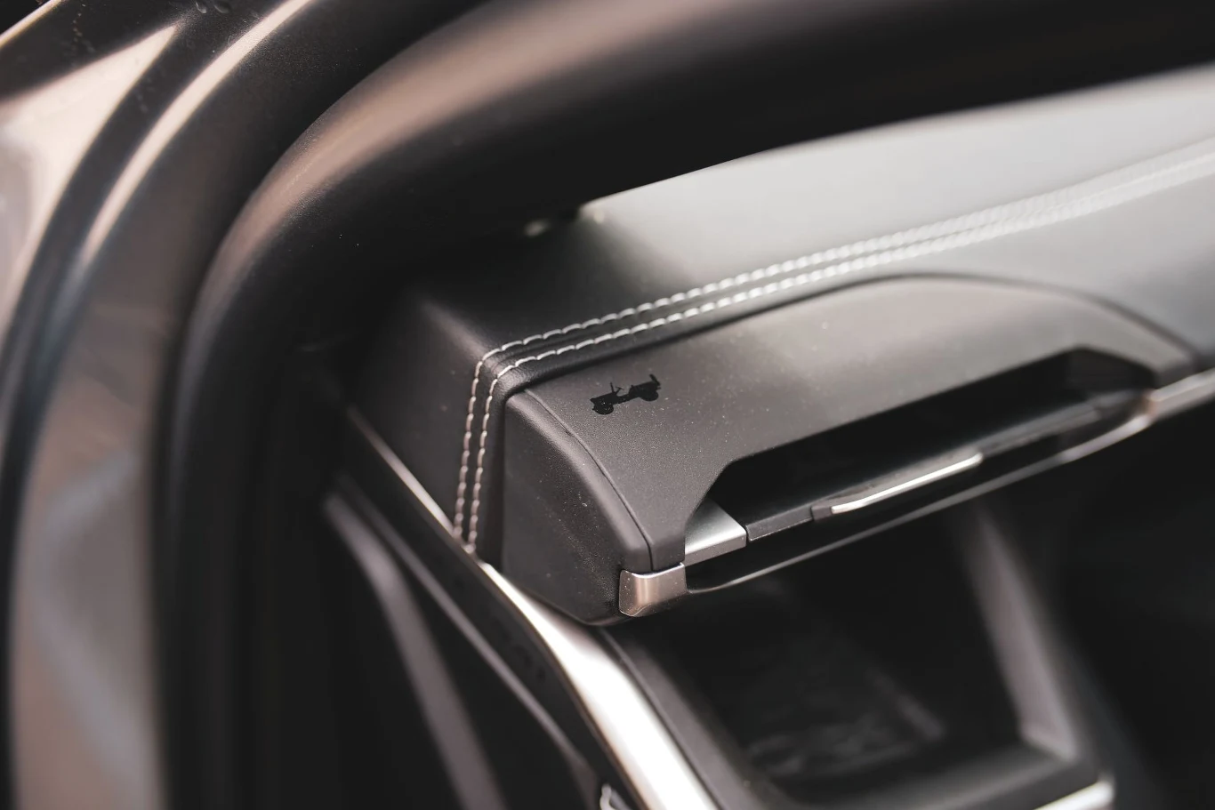 Jeep Compass pełny jest detali nawiązujących do dziedzictwa i wizerunku amerykańskiej marki. Schowek samochodowy z oznaczeniem otwarcia maski oraz widoczną precyzyjną linią przeszycia na desce rozdzielczej.
