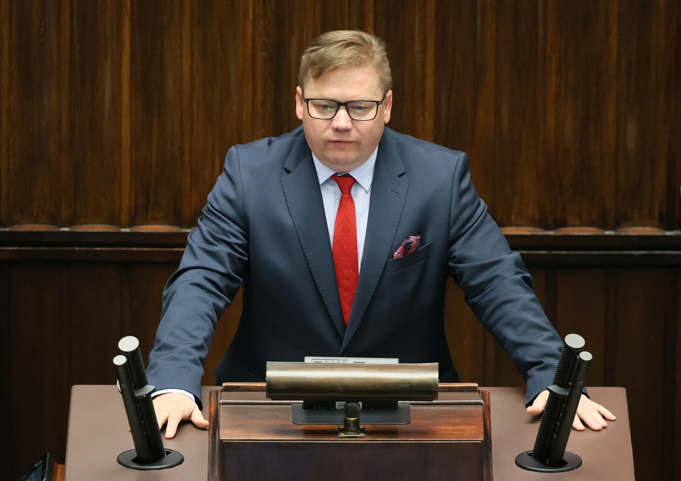Media: Sławomir Ćwik może zostać nowym wiceministrem klimatu Sławomir Ćwik w garniturze i czerwonym krawacie przy mównicy w sali obrad, trzyma ręce na blacie.