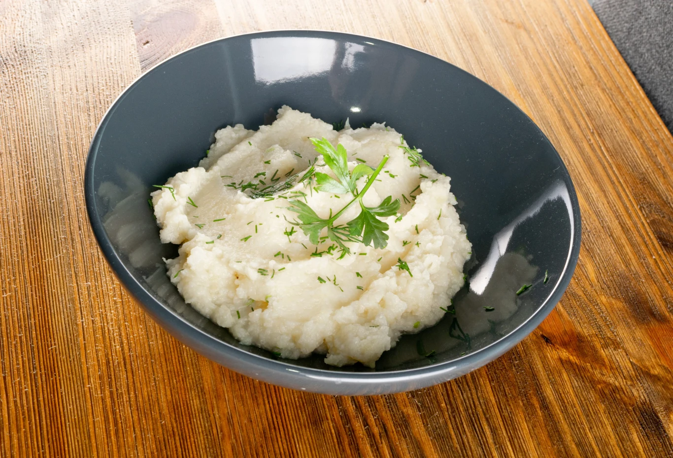 Zdrowe, warzywne purée sprawdzi się idealnie zamiast ziemniaków. Porcja kremowego purée warzywnego posypanego koperkiem i gałązką pietruszki.