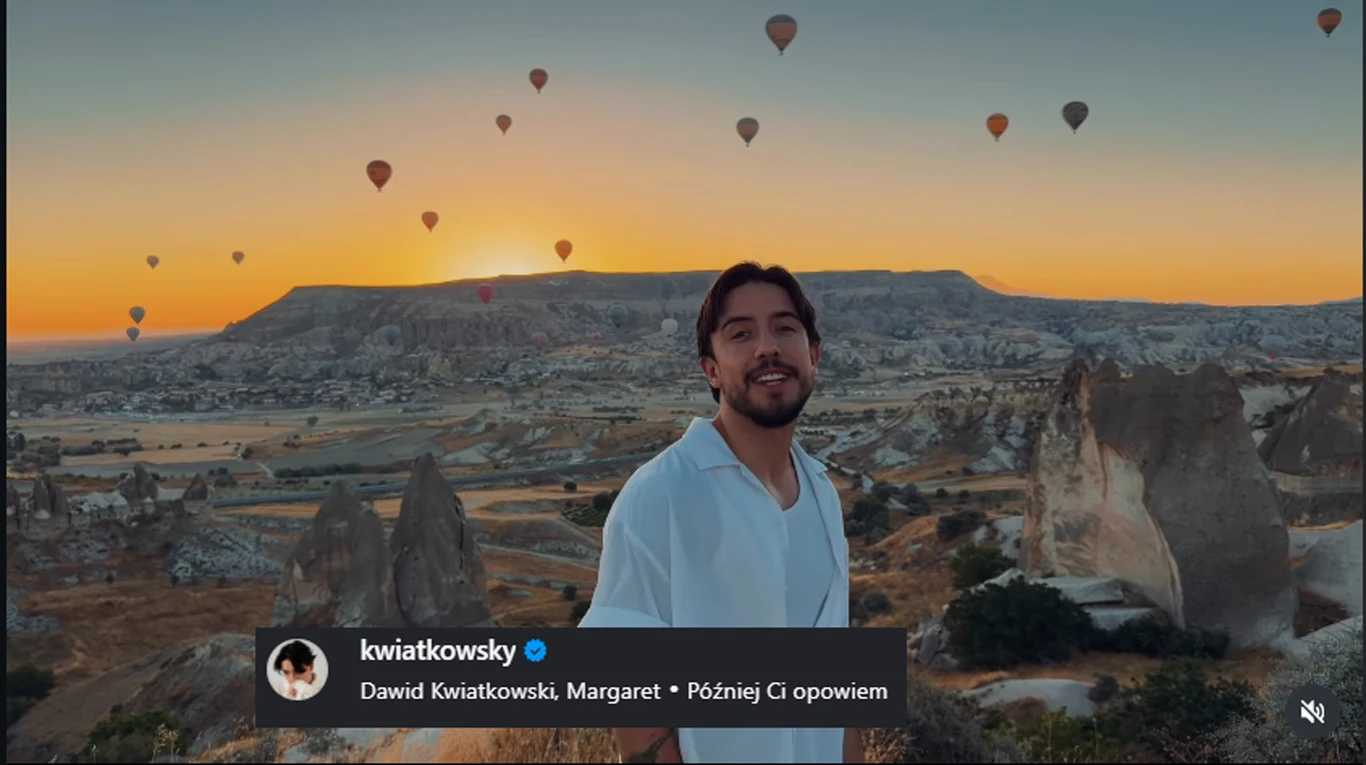 Dawid Kwiatkowski spełnił swoje marzenie /https://www.instagram.com/kwiatkowsky/?hl=pl Mężczyzna w białej koszuli stoi na tle malowniczych formacji skalnych i rozległego krajobrazu, nad którym unoszą się liczne kolorowe balony na ogrzane powietrze podczas zachodu słońca.