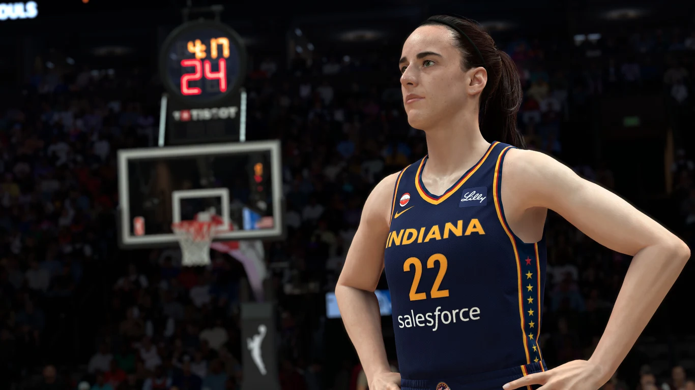 NBA 2K27 Zawodniczka drużyny Indiana w granatowym stroju z numerem 22 stoi na boisku koszykarskim z rękami opartymi na biodrach, w tle widoczna tablica z czasem gry oraz publiczność.