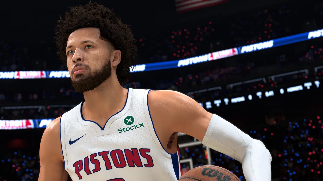 NBA 2K27 Koszykarz w białym stroju Detroit Pistons z piłką w dłoni, skupiony podczas gry na tle rozświetlonej hali sportowej.