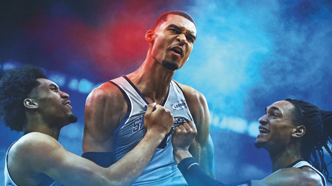 NBA 2K27 NBA 2K27. Trzech koszykarzy celebruje zwycięstwo, centralna postać z napiętymi mięśniami, dwaj pozostali obejmują ją.