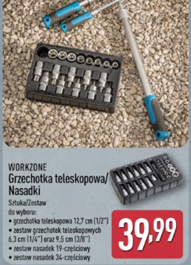 Grzechotka i nasadki Workzone za 39,99 zł. Teleskopowa grzechotka z niebieskimi akcentami oraz zestaw różnych nasadek i adapterów ułożonych w czarnej plastikowej kasecie, całość leży na żwirowej powierzchni.