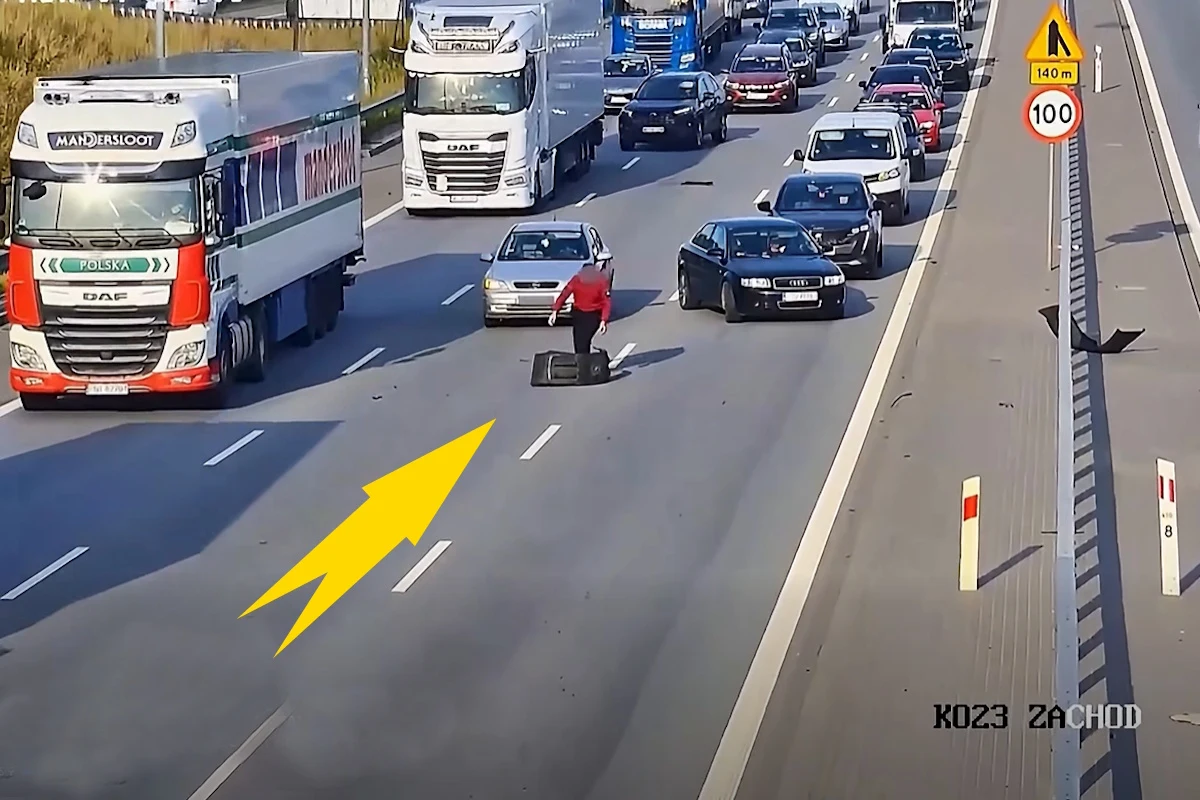 Do niebezpiecznego zdarzenia doszło na drodze ekspresowej S2 w Warszawie Osoba w czerwonej bluzie usuwa duży element z jezdni na drodze S2 wśród spowolnionego ruchu pojazdów.