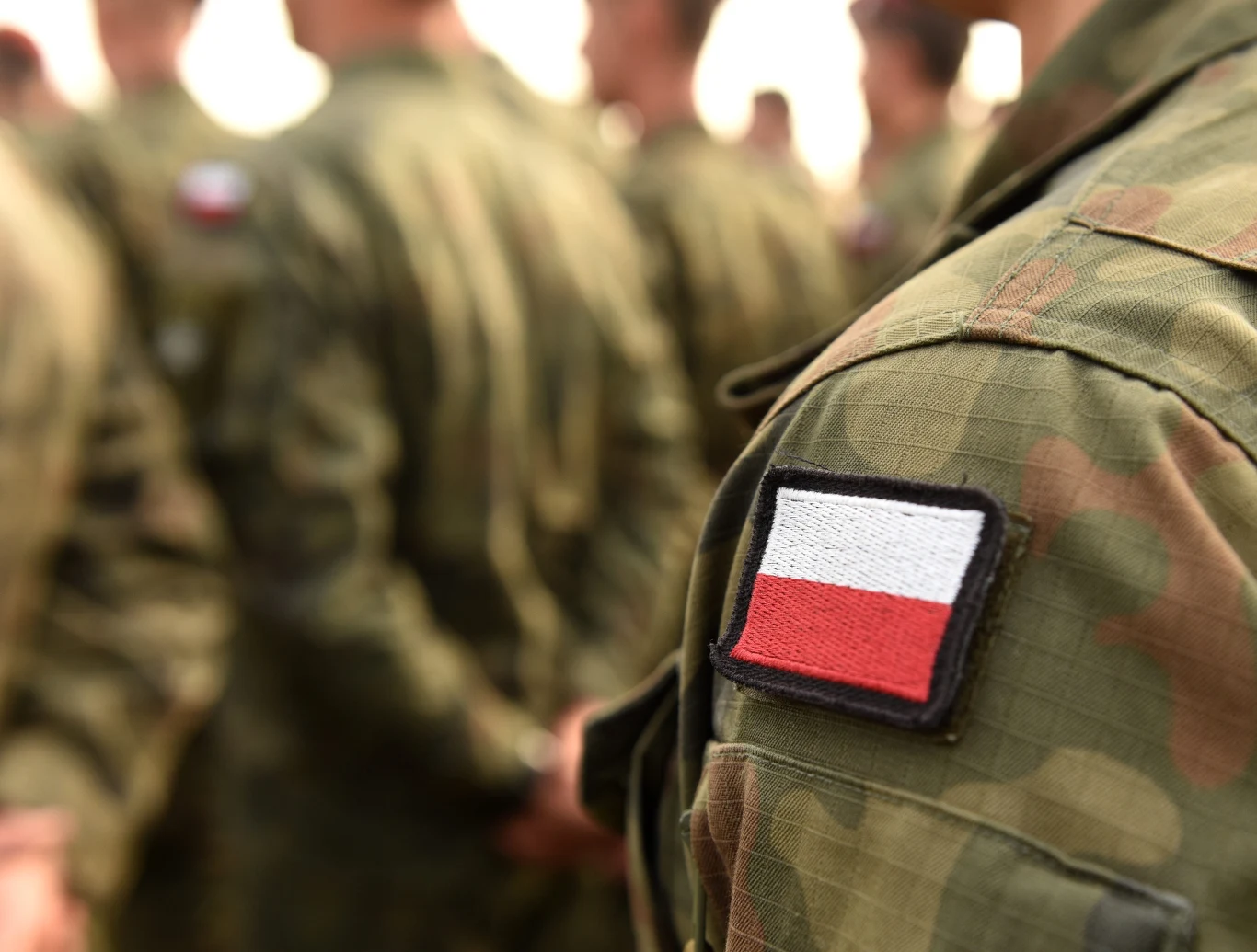Co w przypadku ataku Rosji na kraje bałtyckie? Polacy zabrali głos w sondażu (zdj. ilustracyjne) Żołnierz w polskim mundurze z naszywką flagi Polski na ramieniu, obok inni żołnierze w mundurach