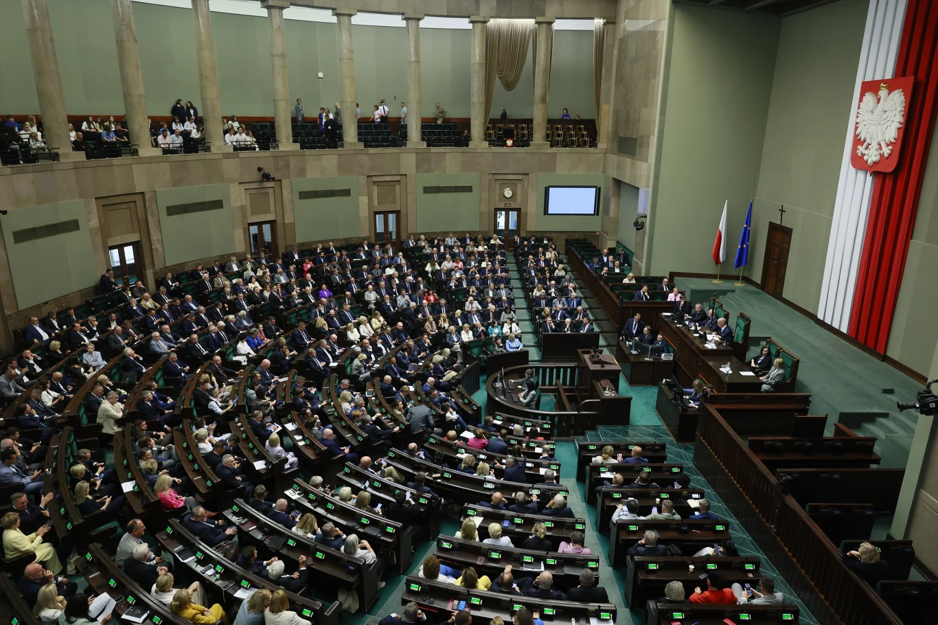 Posłowie wrócą do tematu aborcji? Doniesienia mediów (zdj. ilustracyjne) Obrady plenarne polskiego Sejmu z posłami, mównicą i flagą z godłem Polski na ścianie.