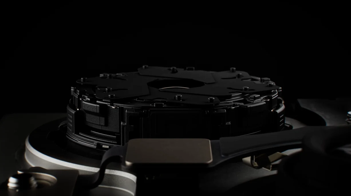 Apple w modelach iPhone 18 Pro i Max umieściło aparat Fusion ze zmienną przysłoną. Czarny mechanizm dysku twardego z widoczną pokrywą talerzy i elementem głowicy na pierwszym planie, oświetlony subtelnym światłem na ciemnym tle.