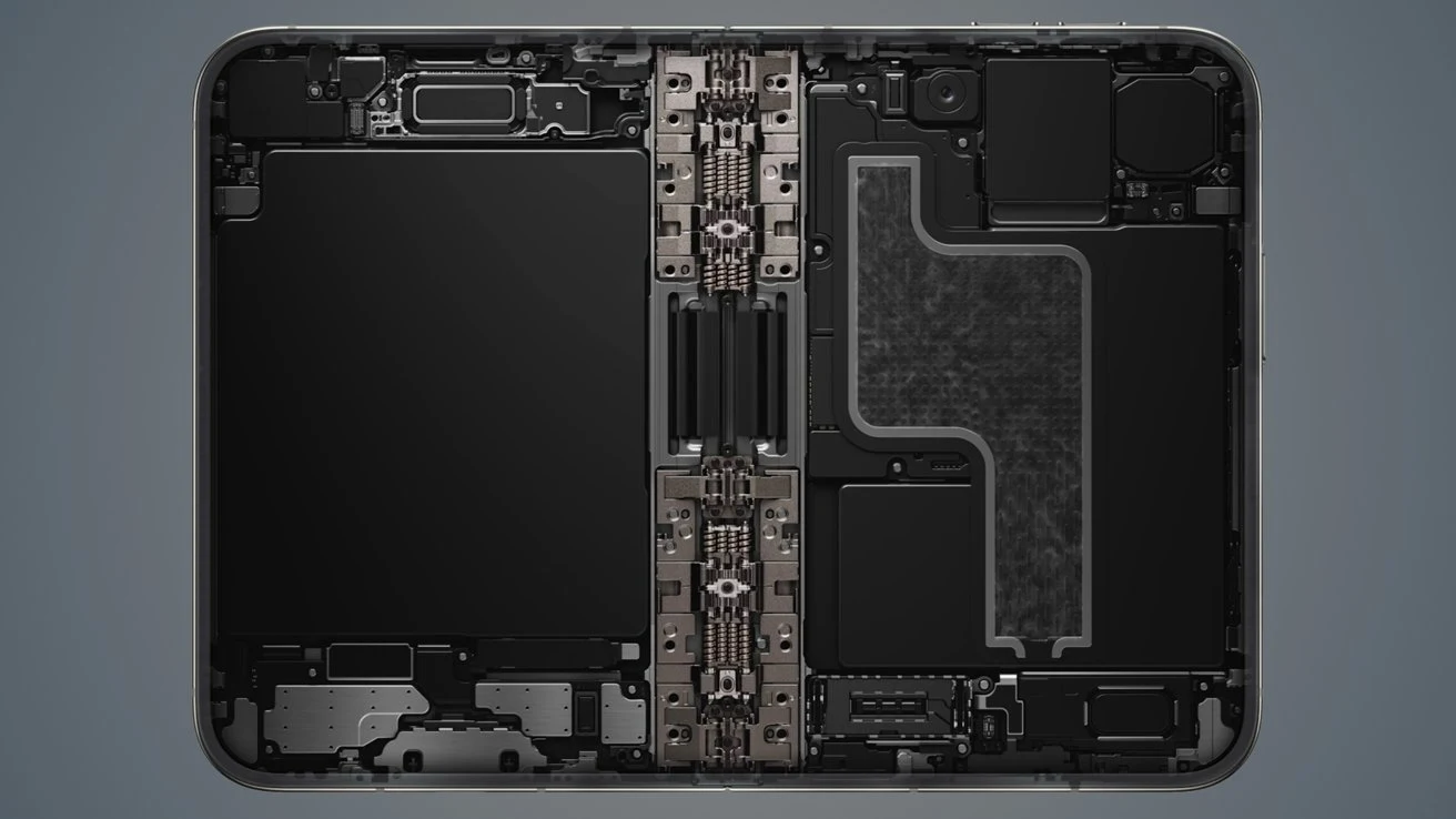 iPhone Duo ma podwójną baterię o łącznej pojemności 4883 mAh. Wnętrze nowoczesnego laptopa z wyeksponowanym centralnym zawiasem oraz komponentami elektronicznymi rozmieszczonymi symetrycznie po obu stronach obudowy.