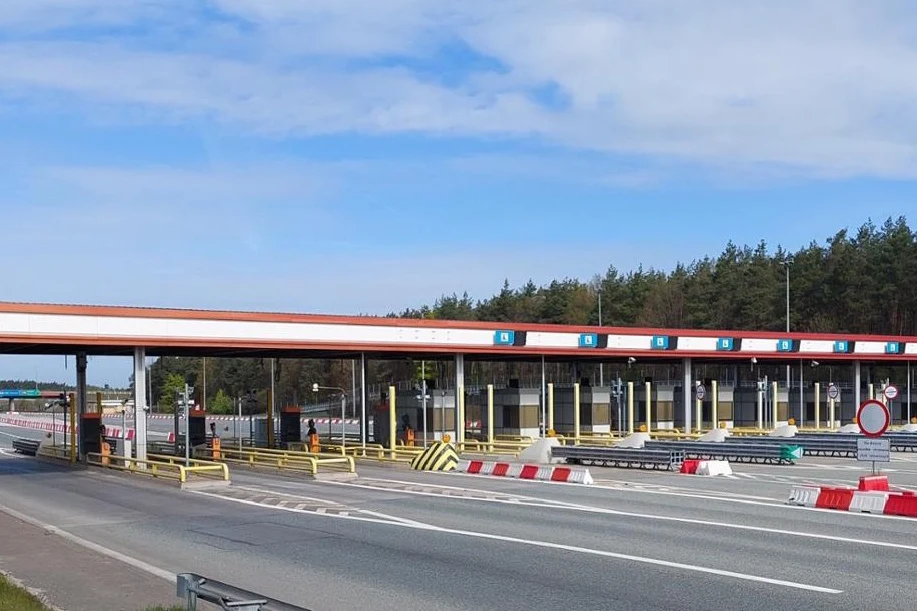 Nieużywane punkty manualnego poboru opłat znikną z autostrady A2 Nieużywany punkt poboru opłat na A2 z szlabanami, oznaczeniami, barierami i pasem lasu w tle.