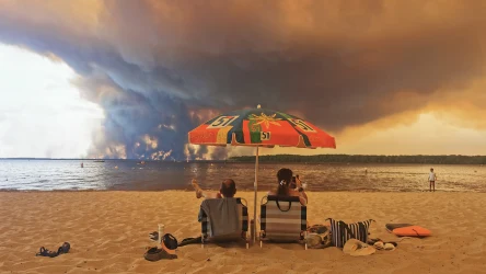 Za nami jeden z najgorszych okresów w historii pomiarów klimatycznych na świecie. Na zdjęciu: plażowicze we Francji obserwujący pożary lasów wywołane skrajną suszą
