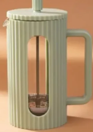 Zielony french press z pionowymi żłobieniami, metalowym tłokiem oraz dużym, prostokątnym uchwytem.