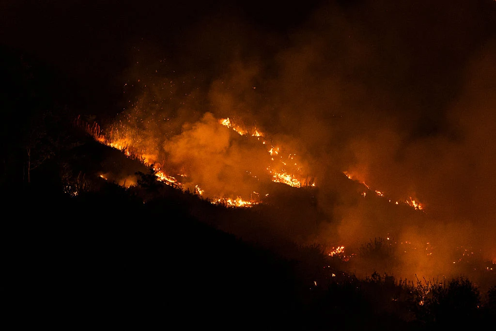 Pożar w Ynysfeio Forest w Walii Intensywny pożar trawiący zbocze wzgórza, gęsty dym i płomienie rozświetlające ciemność nocy.