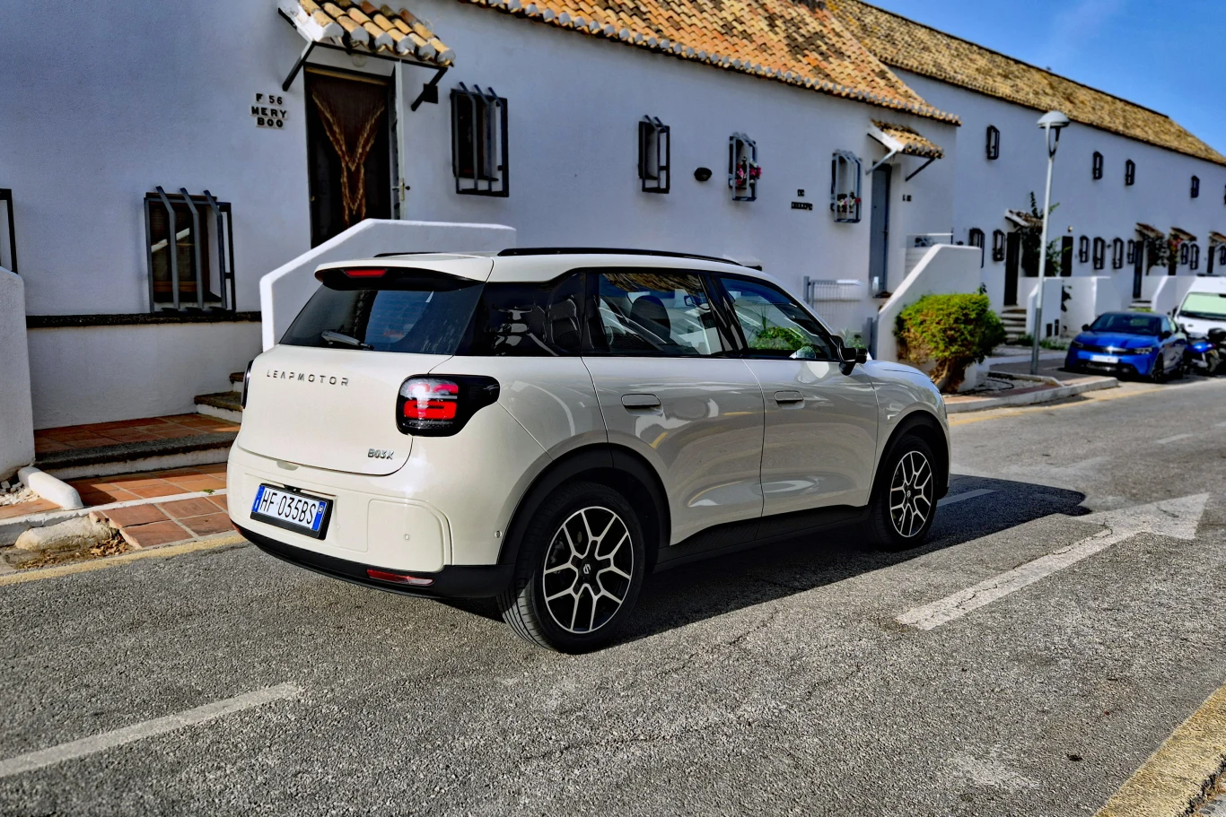 Stylistyka tylnej części nadwozia B03X odbiega nieco od wyglądu innych modeli Leapmotora Biały samochód osobowy DS 3 Crossback zaparkowany przy ulicy obok białych budynków o tradycyjnej architekturze śródziemnomorskiej.