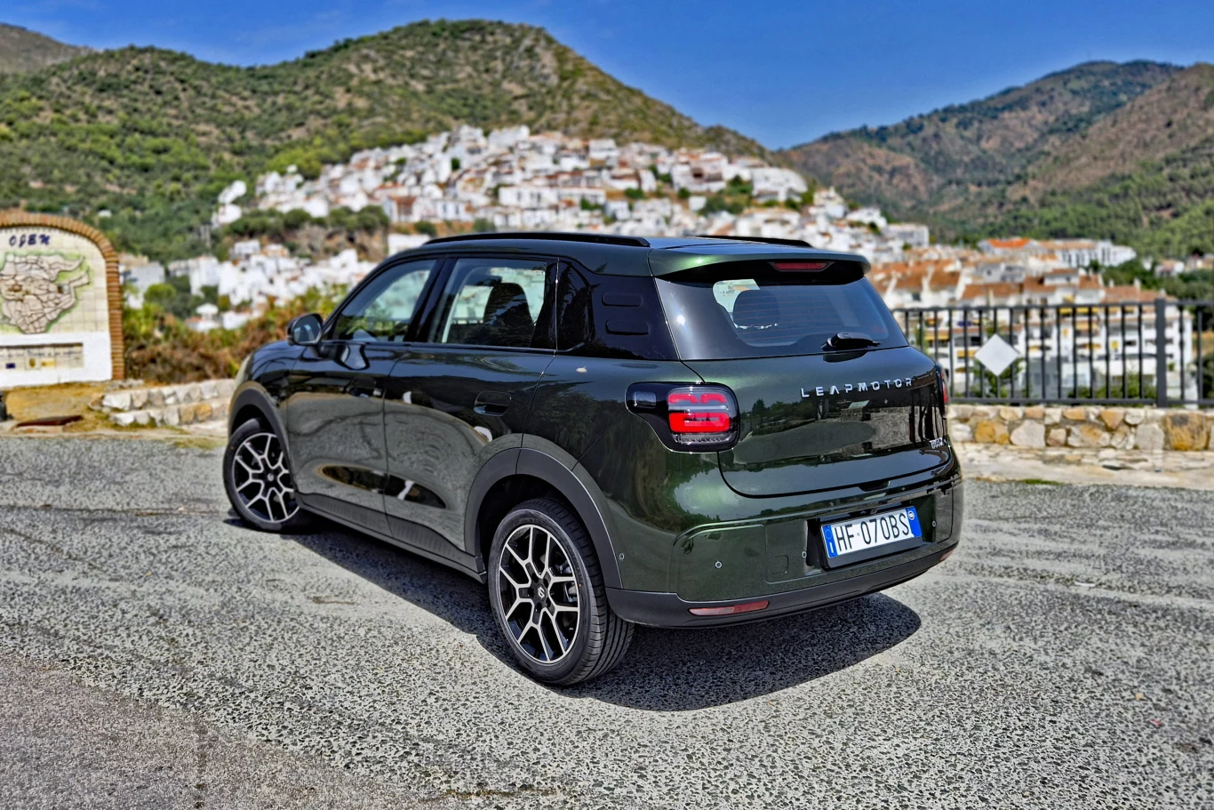 Leapmotor B03X prowadzi się przewidywalnie, a przy tym zapewnia niezły komfort jazdy Zielony samochód osobowy marki Citroën C3 Aircross zaparkowany na drodze z widokiem na białą zabudowę miasteczka położonego na wzgórzu, otoczonego zielonymi wzgórzami.
