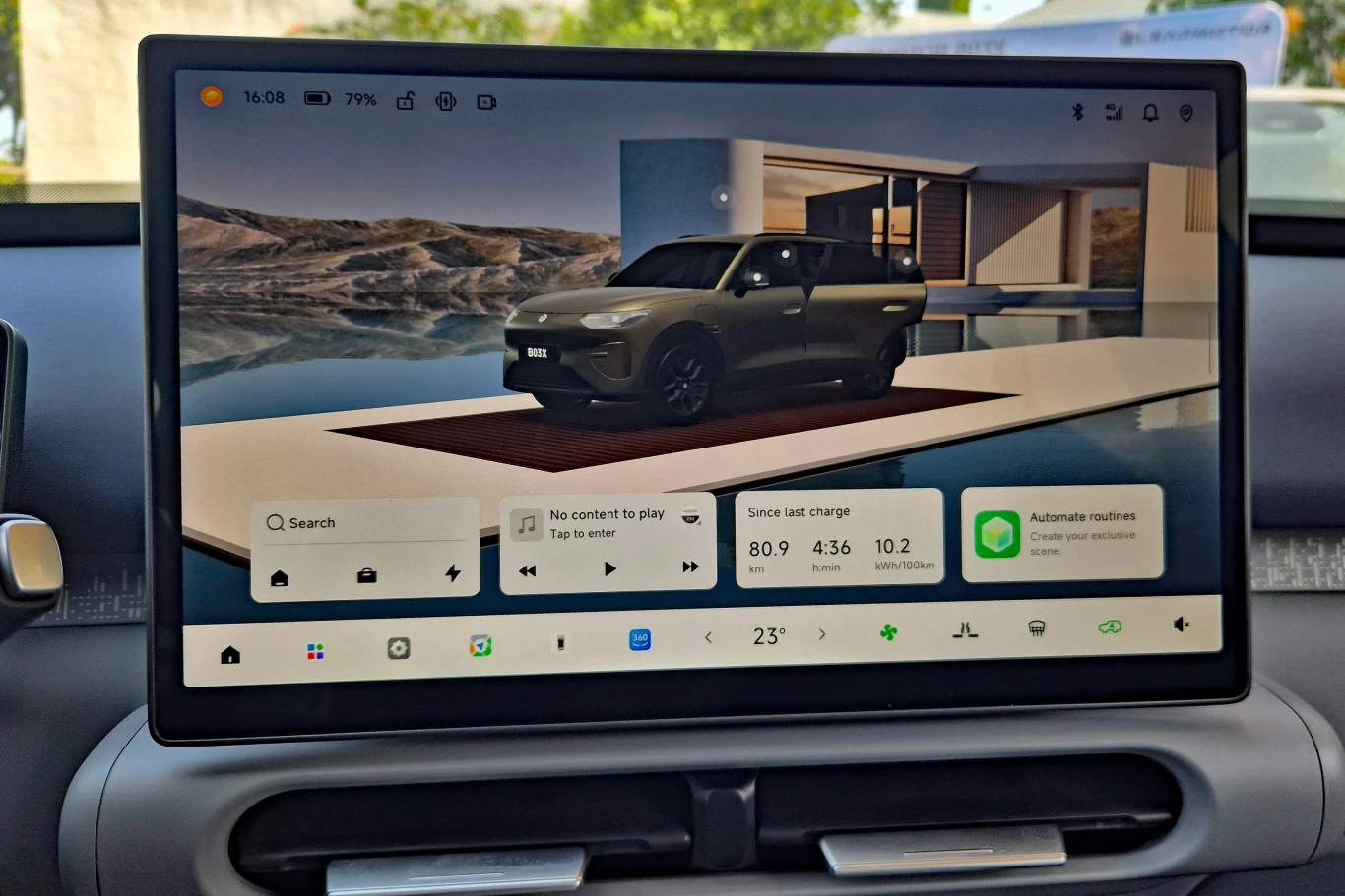 Leapmotor B03X Wyświetlacz samochodowego systemu multimedialnego pokazujący interfejs użytkownika z widocznym elektrycznym SUV-em na tle nowoczesnego budynku i panelami dotyczącymi nawigacji, sterowania muzyką oraz informacji o stanie pojazdu.