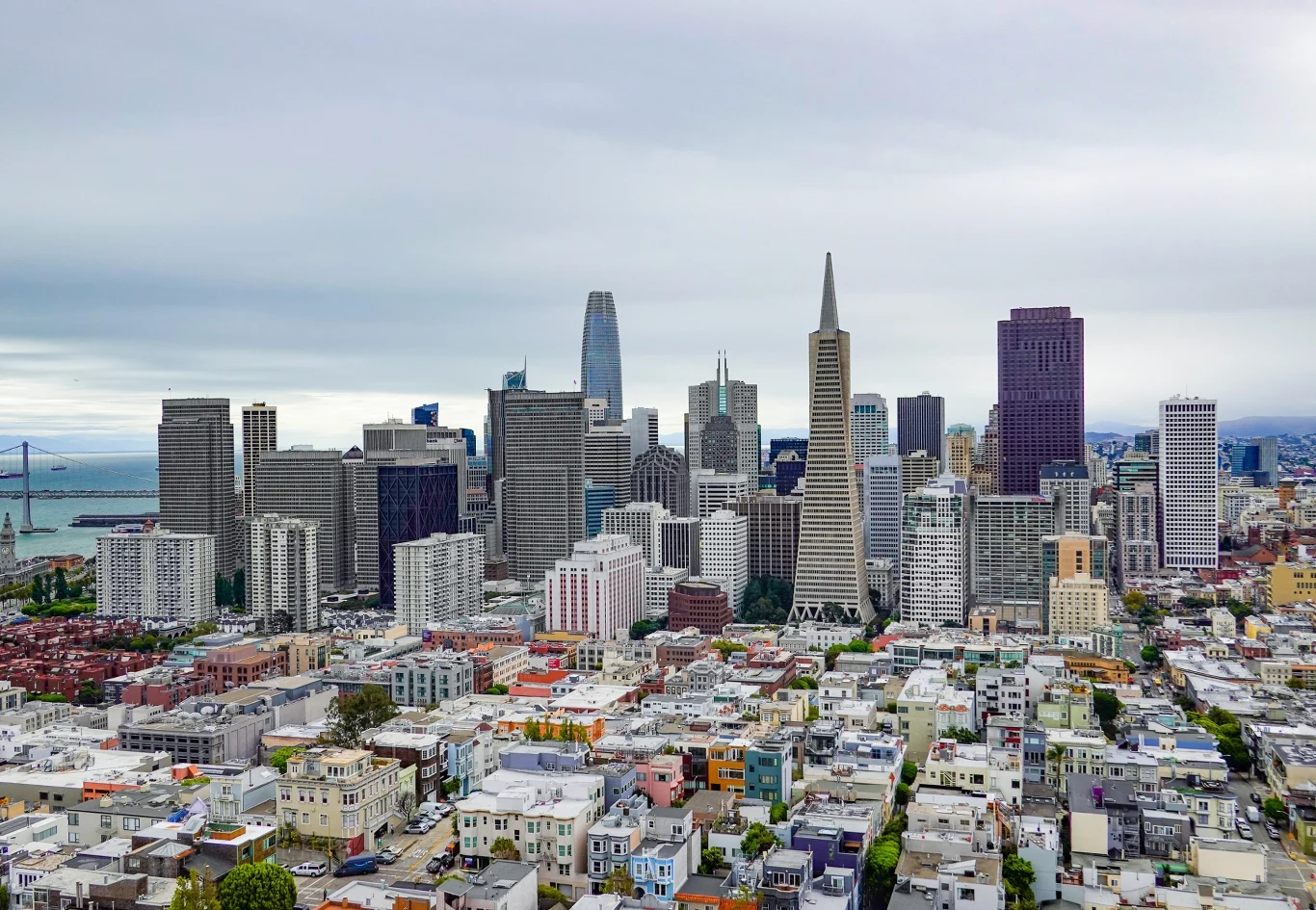 Rynek mieszkaniowy w San Francisco daje nam wgląd w przyszłość. I nie wygląda to zbyt dobrze... Panorama San Francisco z gęsto zabudowaną dzielnicą, wieżowcami i stożkowatym budynkiem na tle zatoki.