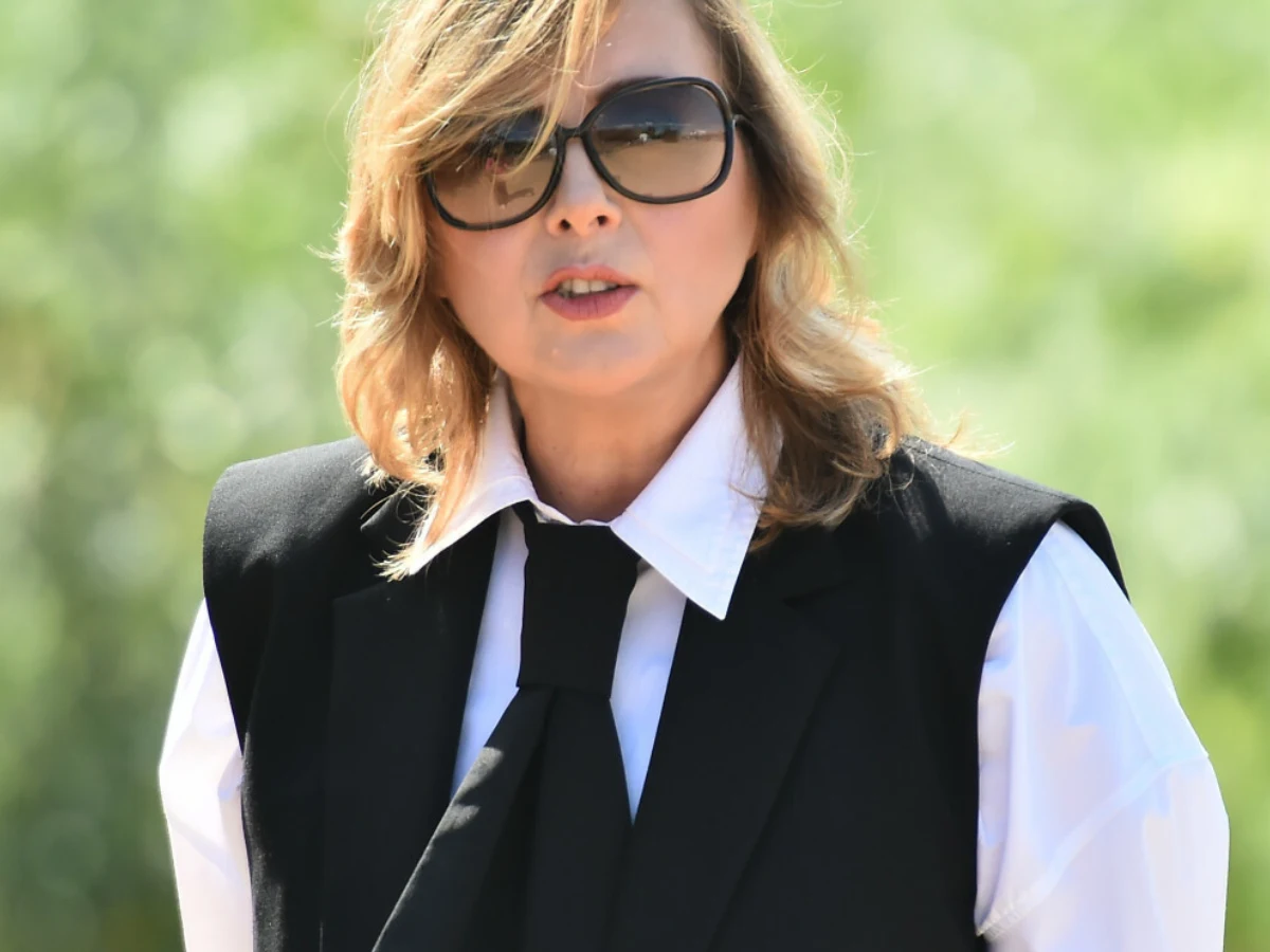 Edyta Bartosiewicz Edyta Bartosiewicz w białej koszuli, czarnej kamizelce i krawacie oraz okularach przeciwsłonecznych.