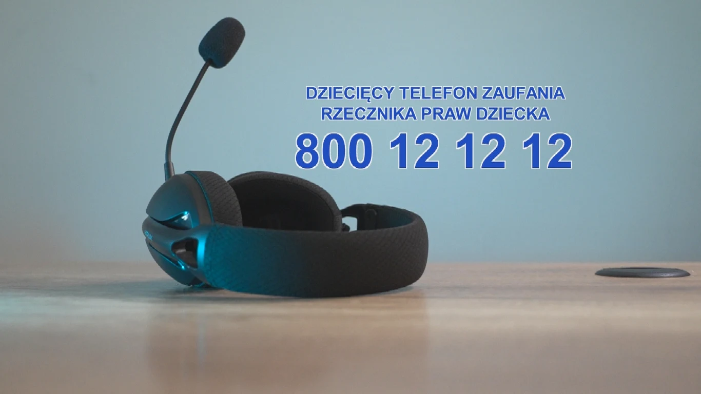Dziecięcy Telefon Zaufania Rzecznika Praw Dziecka Słuchawki z mikrofonem ustawione na jasnym blacie, na tle widoczny duży niebieski numer telefonu 800 12 12 12 oraz napis Dziecięcy Telefon Zaufania Rzecznika Praw Dziecka.