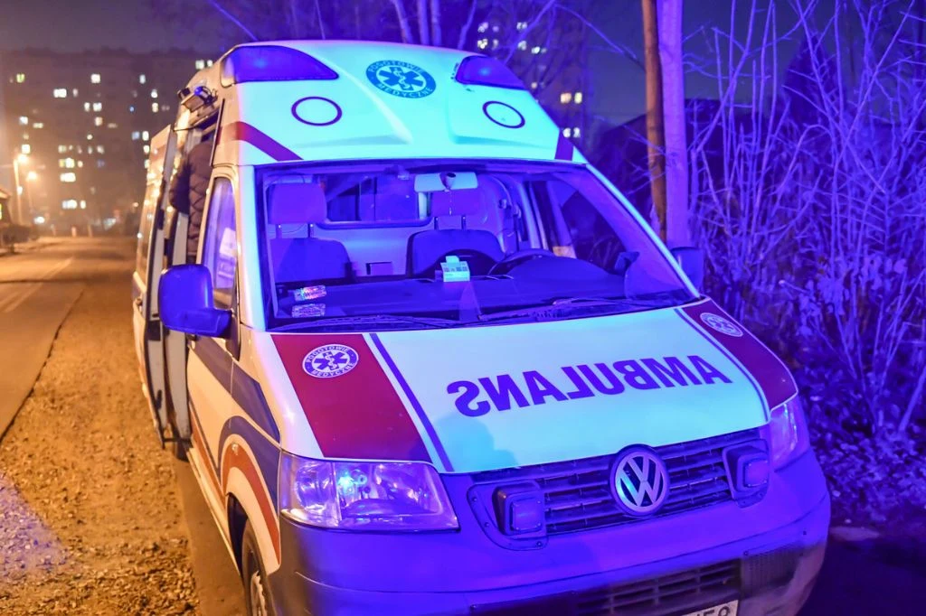 Konin. 88-latka wypadła z okna szpitala. Kobieta nie przeżyła (zdj. ilustracyjne) Karetka pogotowia ratunkowego z włączonymi niebieskimi światłami zaparkowana przy ulicy