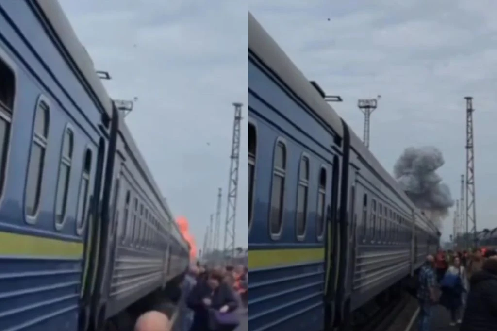 Atak na pociąg w pobliżu granicy polsko-ukraińskiej Tłum ludzi przy niebieskim pociągu na stacji, w tle dym i ogień po ataku niedaleko granicy polsko-ukraińskiej.