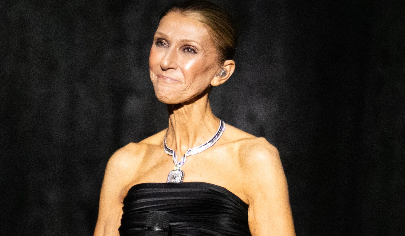 Celine Dion Celine Dion na scenie podczas koncertu w Paryżu. Wokalistka w czarnej sukni trzyma mikrofon.