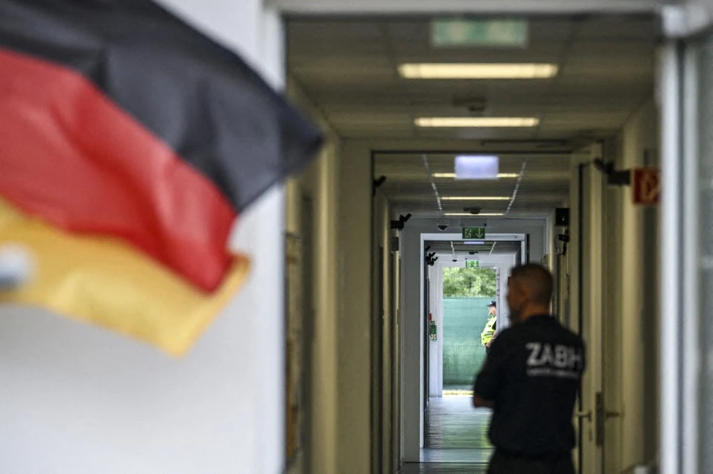 W Nadrenii Północnej-Westfalii planowana jest budowa ogromnego ośrodka deportacyjnego Flaga Niemiec przy wejściu do jasnego korytarza ośrodka deportacyjnego, funkcjonariusz ZABH tyłem.