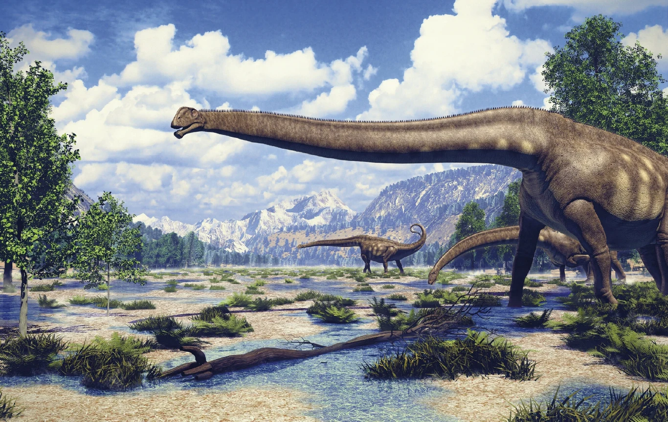 Grupa długoszyich dinozaurów poruszających się po rozległej, podmokłej równinie z górskim krajobrazem w tle oraz rosnącymi wokół drzewami.