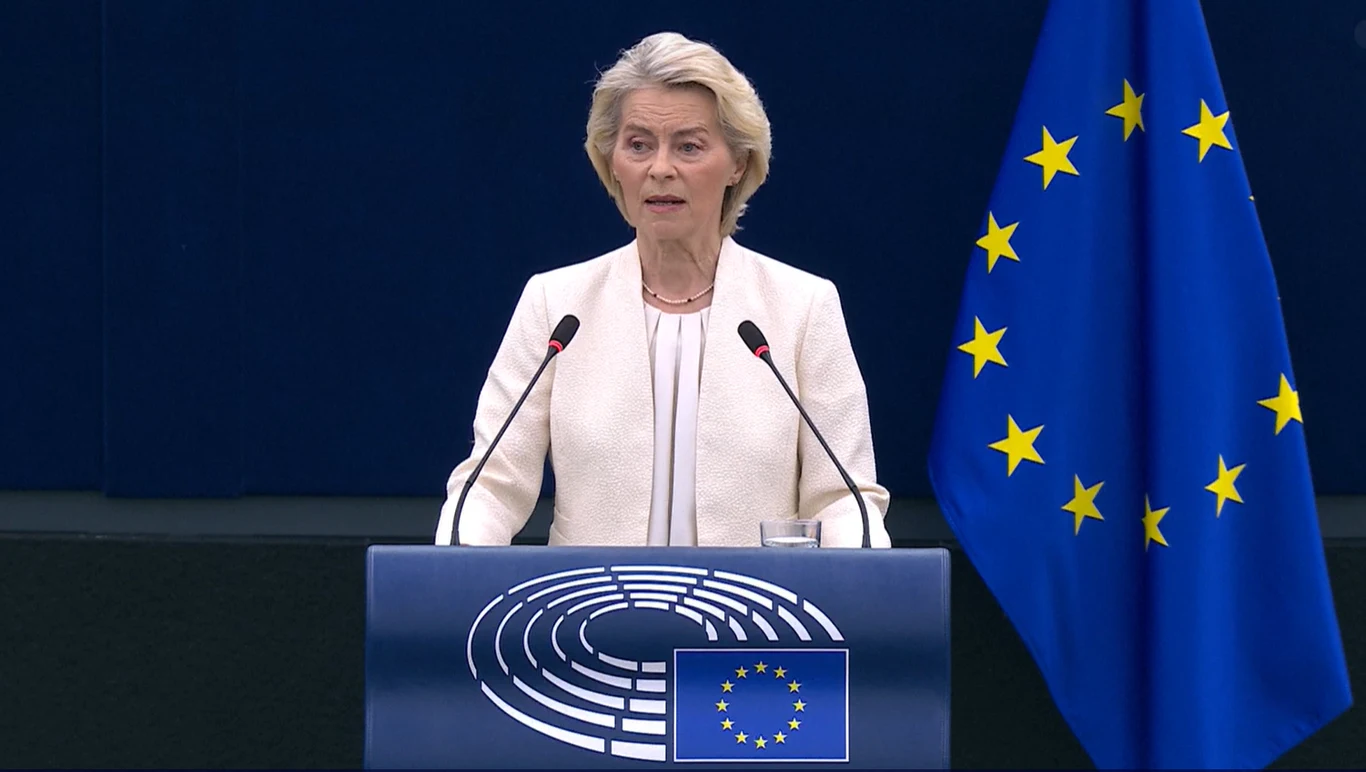 Ursula von der Leyen podczas wygłaszania orędzia o stanie Unii Europejskiej Ursula von der Leyen przemawia przy mównicy Parlamentu Europejskiego, obok flaga UE.