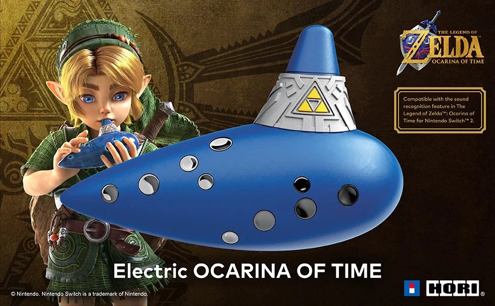 HORI Electric Ocarina of Time Link z gry The Legend of Zelda gra na niebieskiej elektrycznej okarynie ozdobionej symbolem Triforce, widoczny wyraźny napis Electric OCARINA OF TIME oraz logo gry w prawym górnym rogu.