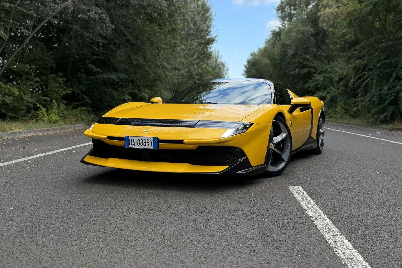 Ferrari 849 Testarossa ma 1050 KM i robi setkę w czasie poniżej 2,3 s. Ferrari 849 Testarossa w żółtym kolorze na asfaltowej drodze, widoczne duże felgi i kanciasty przód.