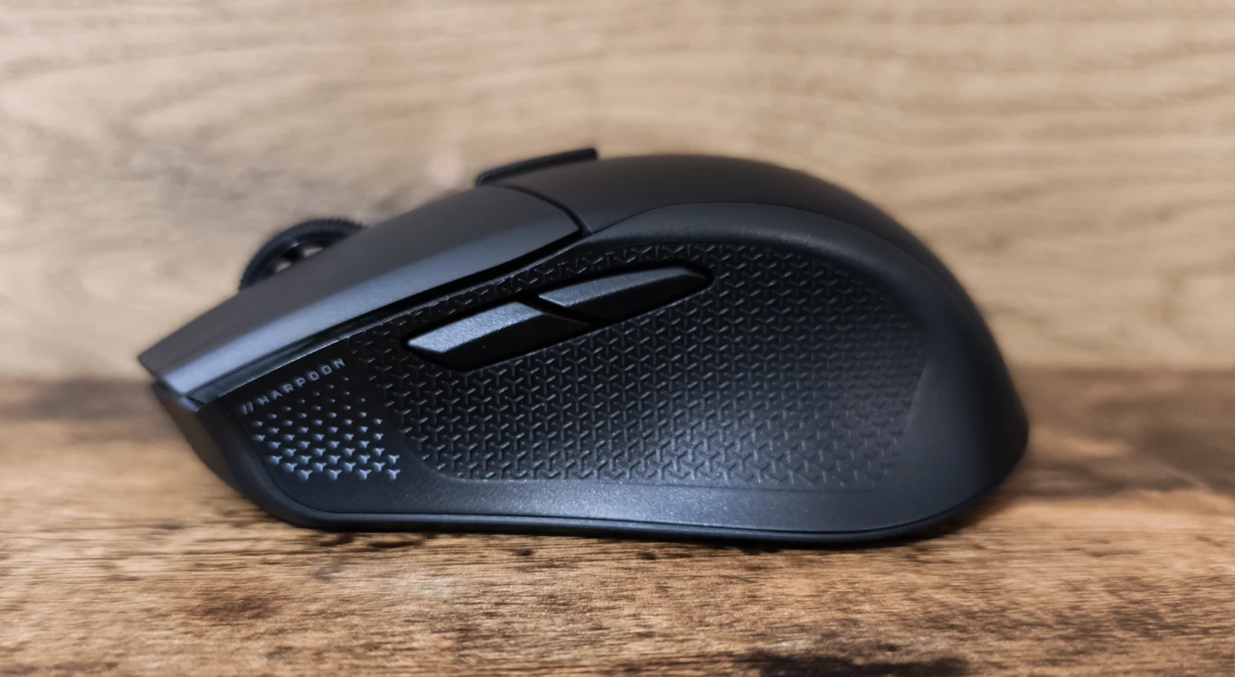 Corsair Harpoon V2 Wireless Czarna bezprzewodowa mysz komputerowa z dwoma bocznymi przyciskami, o lekko chropowatej powierzchni zapewniającej lepszy chwyt, ustawiona na drewnianej powierzchni.
