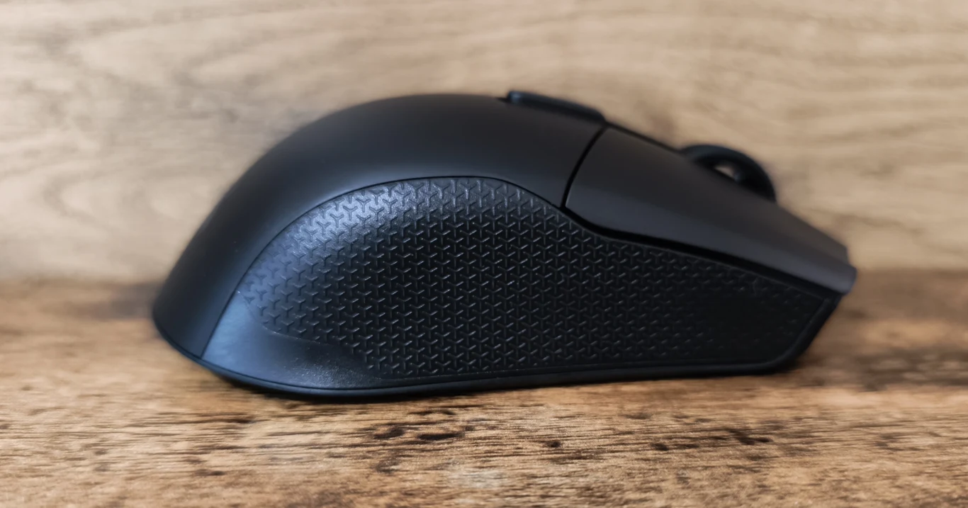Corsair Harpoon V2 Wireless Czarna mysz komputerowa z wyprofilowanym, teksturowanym bokiem, ustawiona na drewnianej powierzchni.